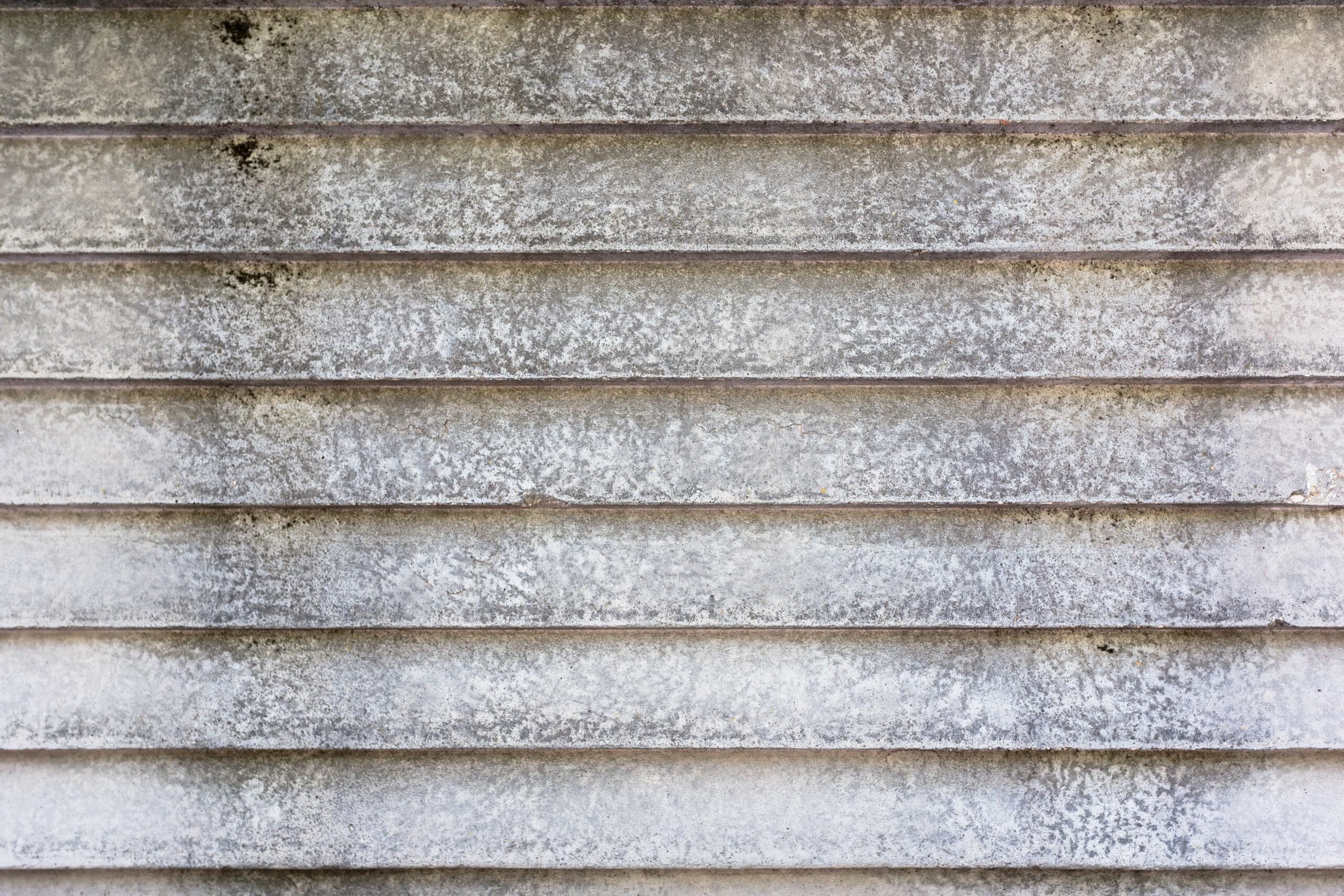A close-up texture shot of weathered grey horizontal house siding heavily covered in black mold, mildew, and grime, highlighting the need for professional siding pressure washing in Fort Lauderdale, Florida.